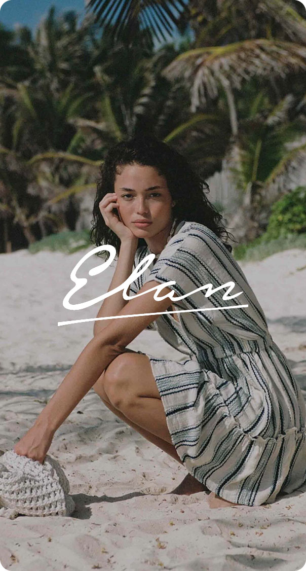 woman sitting on sandy beach wearing light summer dress, relaxed coastal fashion lifestyle
