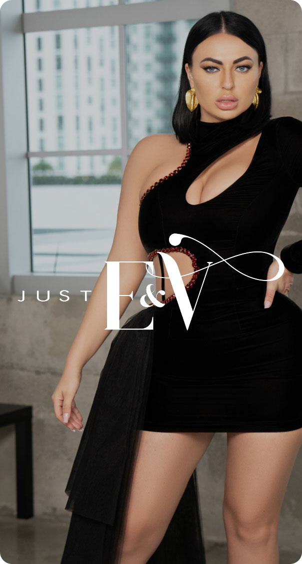 woman wearing black cut-out mini dress with gold earrings posing indoors luxury fashion
