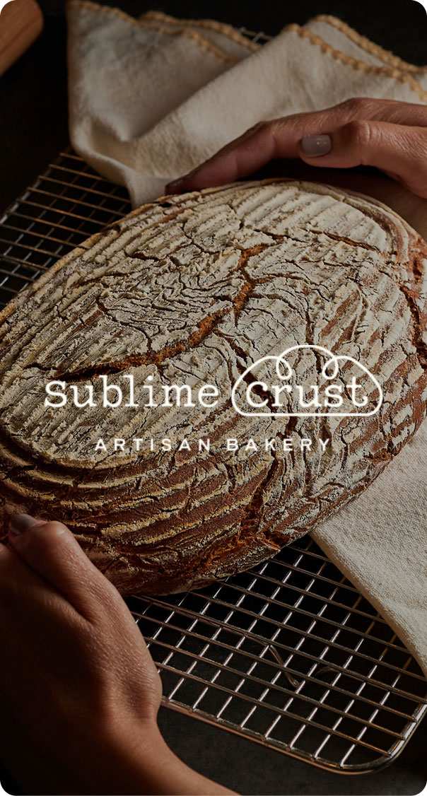 Artisan sourdough bread on cooling rack with rustic texture, representing Sublime Crust bakery branding