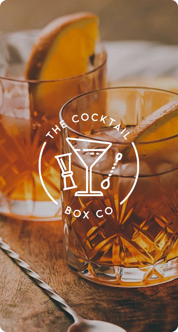 old fashioned cocktails with orange peel garnish in crystal glasses on wooden bar, premium cocktail presentation and mixology concept