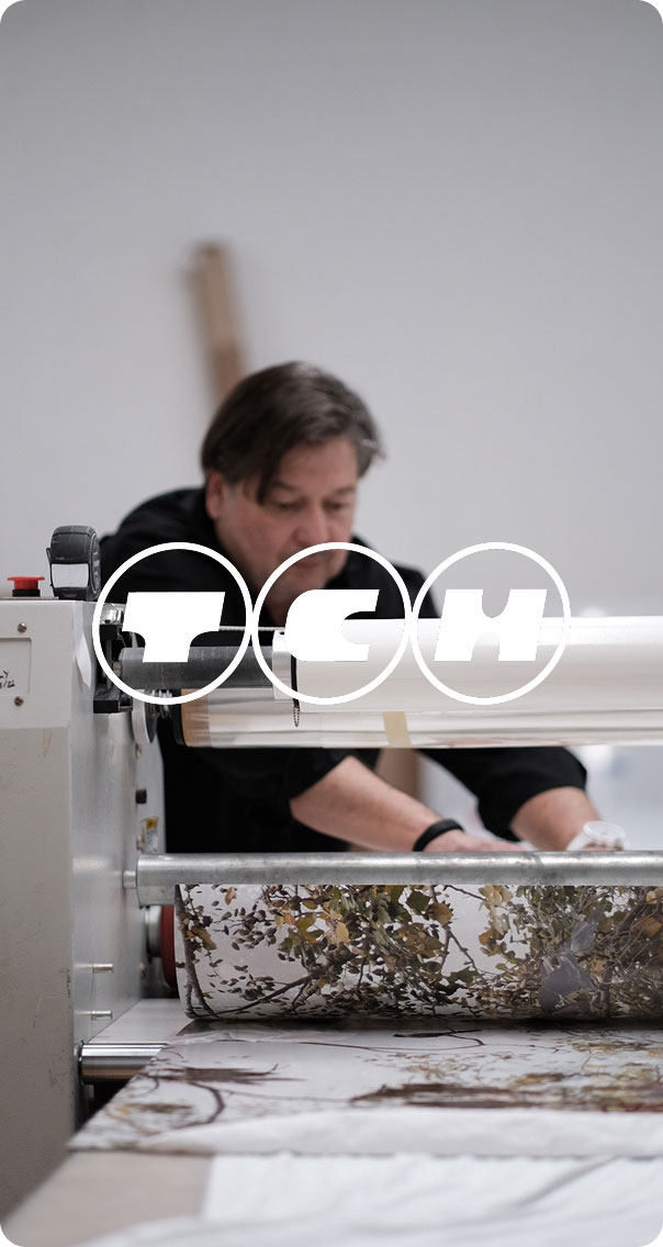 operator working on large format printer processing printed material